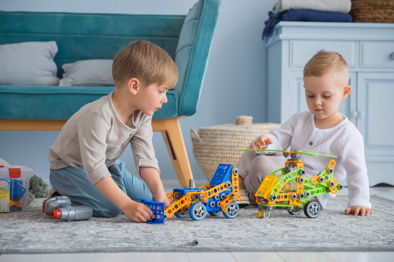 Two young boys enjoying playtime indoors with colorful construction toys.